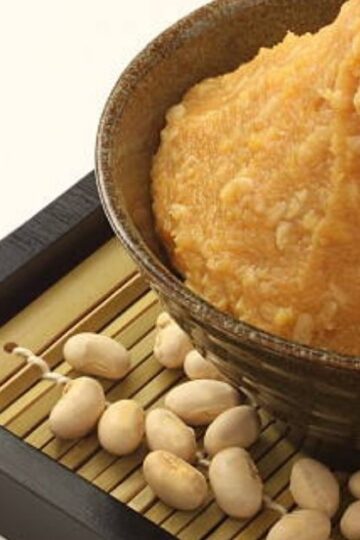 white miso paste in a ceramic bowl with wooden spoon