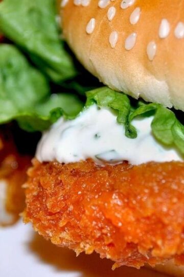 Crispy chicken cutlet sandwich with melted mozzarella, lettuce, tomato, and garlic aioli on toasted bread